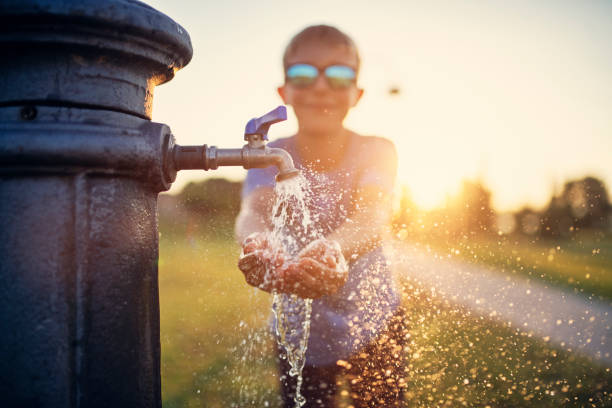 pequeno menino beber água de fonte pública - faucet water tap heat - fotografias e filmes do acervo