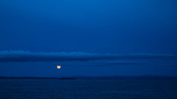 istock Moon on a blue sky at Isle of Arran 1074376984