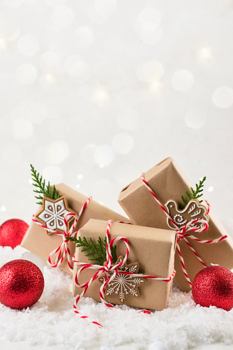 Christmas gift or present box wrapped in kraft paper with decoration on white background. Present decorated with natural parts. Copy space