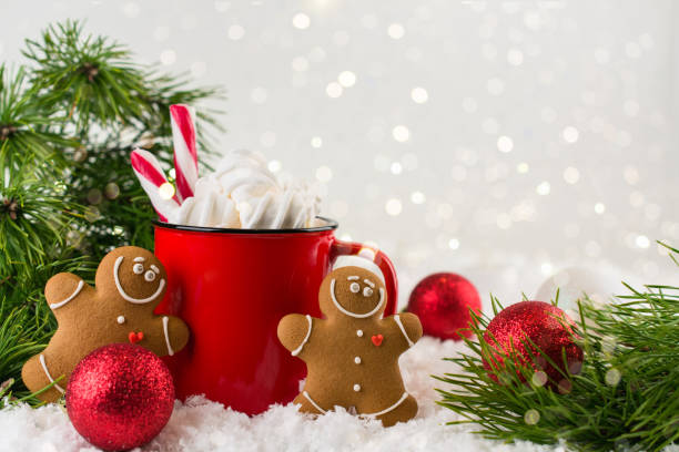 istock Cozy winter composition with a red cup of hot chocolate with marshmallows gingerbread man cookies  on a light festive background. 1074391108