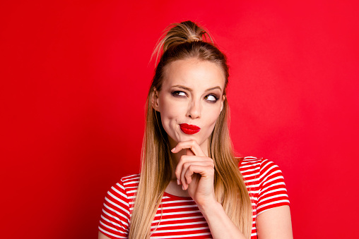 Close-up portrait of nice shine cute funny adorable charming attractive girl wearing striped top touching chin looking aside isolated over bright vivid red background