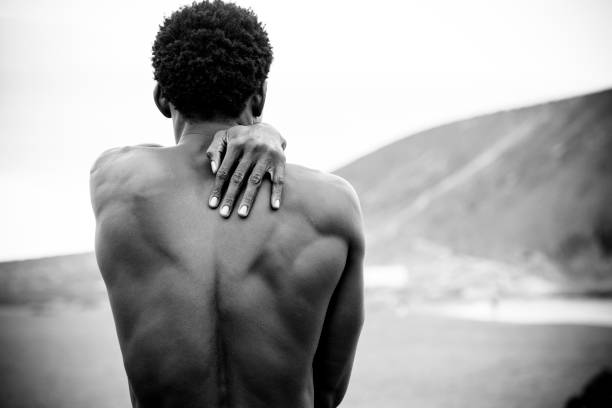 istock Protect and love conceptual image with black man african race viewed from behind with a man on his shoulder. clack and white fine art picture. nice body with muscles and lovely message 1074392208