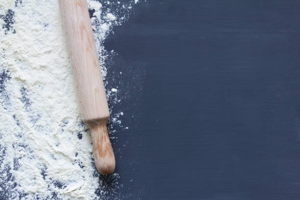 istock white flour and rolling pin on dark background 1074407324