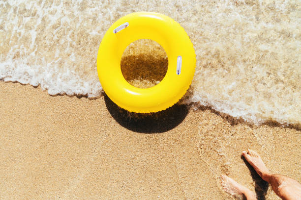 istock Yellow rubber ring on a breaking wave at the waters edge, Pedn Vounder Beach, Cornwall on a bright sunny day. 1074413866