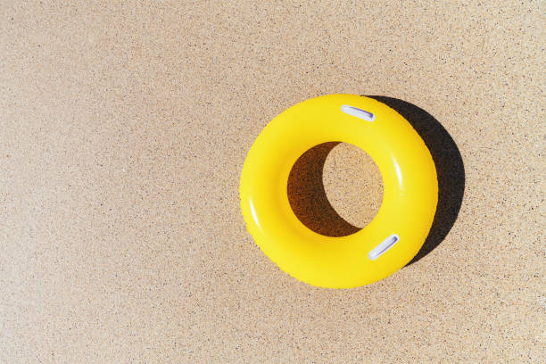 istock Yellow rubber ring on the sand from above. 1074413904