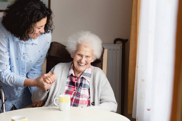 年配の女性のケアと支援を得る - senior adult home caregiver care community outreach ストックフォトと画像