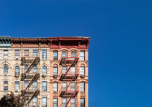 Colorful historic buildings on 4th Street in the East Village of Manhattan in New York City with empty blue sky background