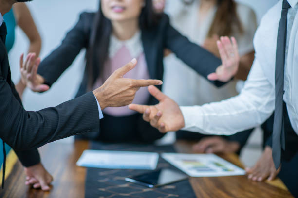 Asian women mediating disagreement A woman in the background is mediating a disagreement between two men in this close-up. A finger is being pointed at one guy while the other is not assuming responsibility. arguing stock pictures, royalty-free photos & images