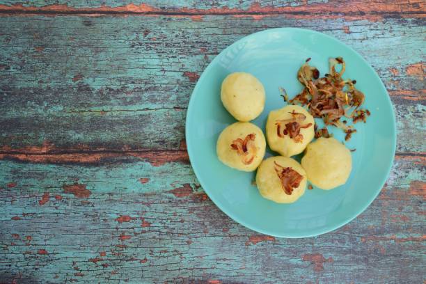 knödel oder deutsch kartoffelknödel mit karamellisierten zwiebeln - deutsche knödel draufsicht stock-fotos und bilder