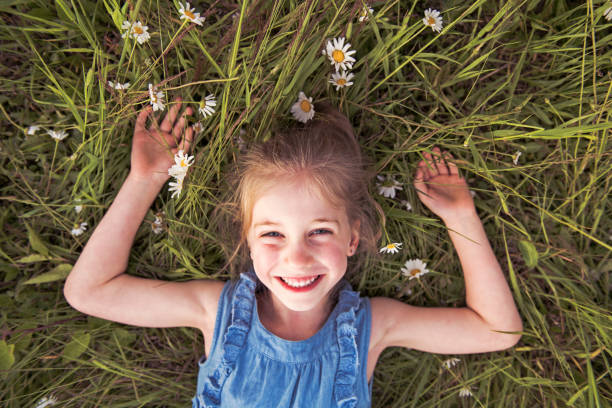 istock child on green daisy grass in a summer park sunset time 1074468206