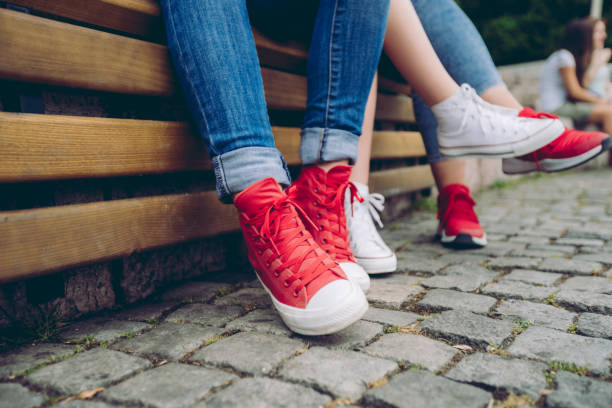 Close up of three girlfriends sitting on a bench