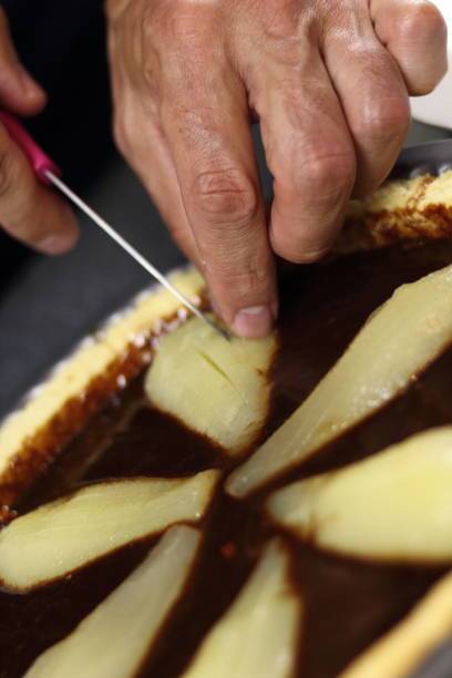 istock Chef cutting pears in chocolate filling with knife 1074473786