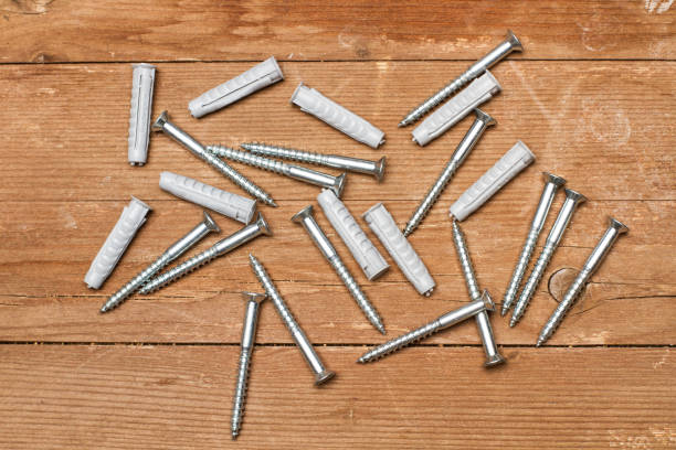 istock Screws on a wooden table 1074482176