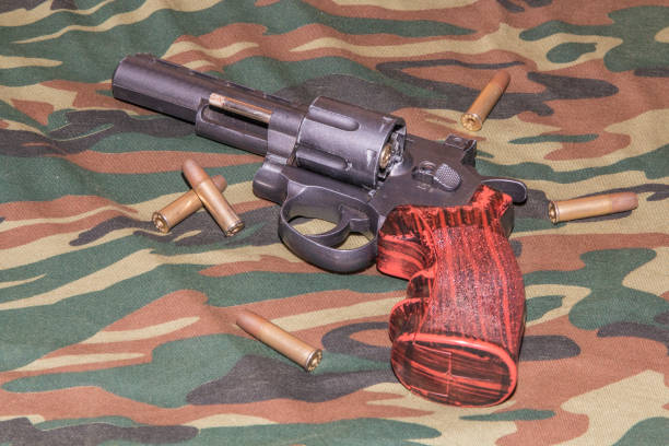 istock Revolver on camouflage background. Pneumatic gun 4,5 mm 1074497768