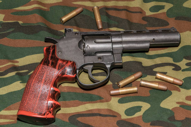 istock Revolver on camouflage background. Pneumatic gun 4,5 mm 1074497984