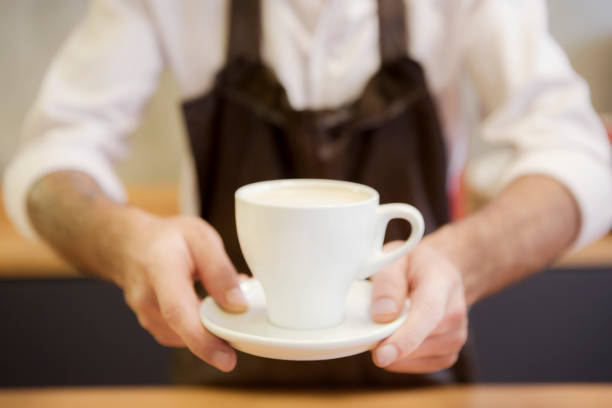 Barista serving cup of fresh coffee