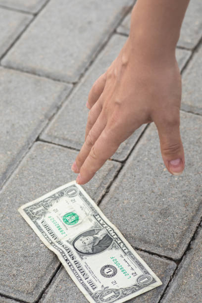 istock Woman is picking one dollar banknote from the ground. 1074499524