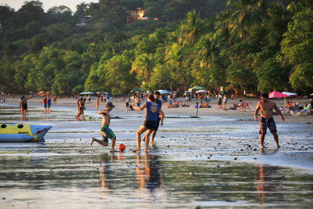 Women and men playing football at sunset in Espadilla Beach, next Manuel Antonio National Park, in Costa Rica's Pacific coast Manuel Antonio, Costa Rica – November 18, 2018: Women and men playing football at sunset in Espadilla Beach, next Manuel Antonio National Park, in Costa Rica's Pacific coast manuel antonio national park stock pictures, royalty-free photos & images