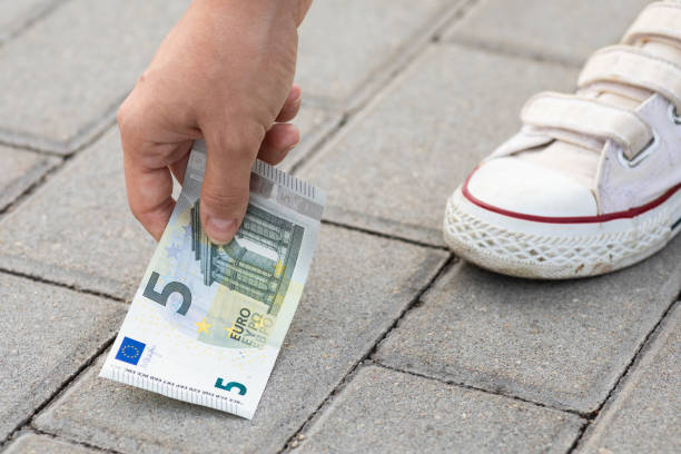 istock Woman is picking five euro banknote from the ground 1074499702