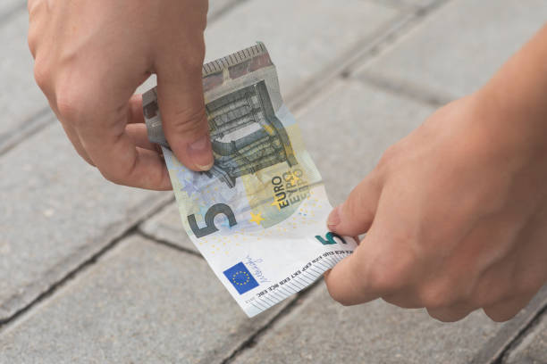 istock Woman is picking five euro banknote from the ground 1074499846
