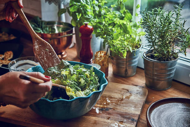 Preparing Cesar Salad with Chicken, Lettuce and Parmesan