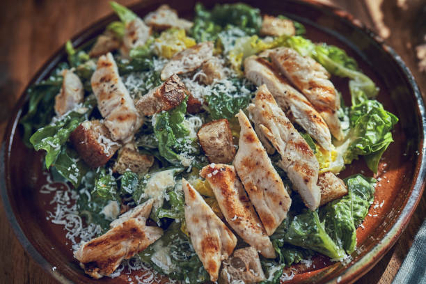 istock Preparing Cesar Salad with Chicken, Lettuce and Parmesan 1074506574