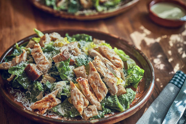 istock Preparing Cesar Salad with Chicken, Lettuce and Parmesan 1074506592