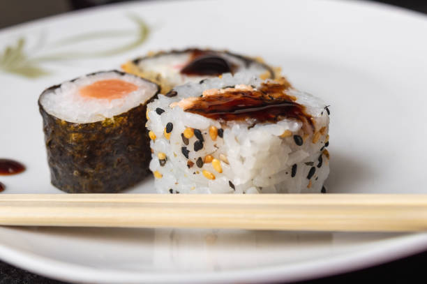 istock Uramaki and Hot Roll on a plate with chopsticks 1074507614