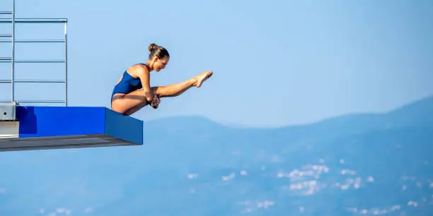 Photo of Female springboard diver before jump