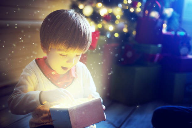 istock Surprised child opening and looking inside a magic gift over Christmas tree 1074512258