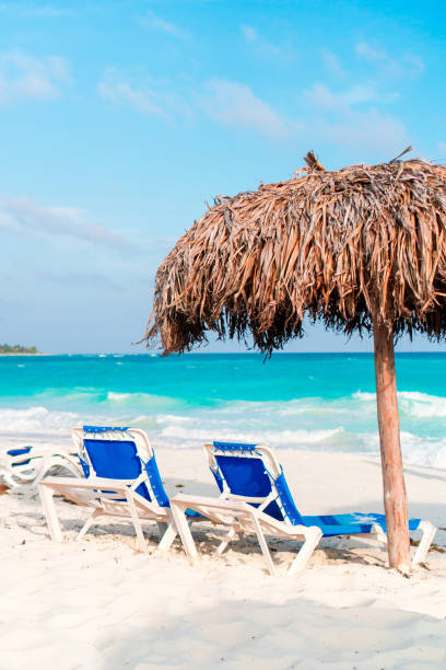 istock Beach sunbeds and umbrella on white beach 1074515374