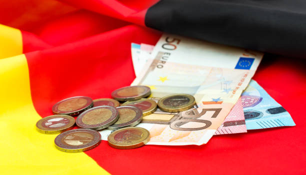 istock Euro bills with coins on German flag. 1074521396