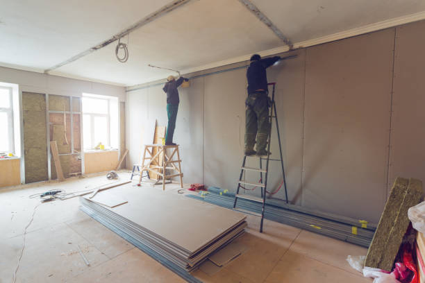 istock Workers are installing plasterboard (drywall) for gypsum walls in apartment is under construction, remodeling, renovation, extension, restoration and reconstruction. 1074526672