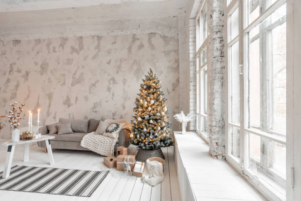 istock Light living room with Christmas tree. Comfortable sofa, high large Windows. Light white brick wall. 1074529850