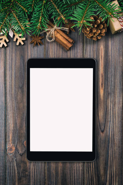 istock Digital tablet mock up with rustic Christmas vintage, toned wood background decorations for app presentation. top view with copy space 1074532582