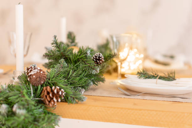 istock Christmas table setting. Beautiful served table with decorations, candles and lanterns. Living room decorated with lights and Christmas tree. 1074551904