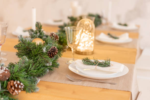 istock Christmas table setting. Beautiful served table with decorations, candles and lanterns. Living room decorated with lights and Christmas tree. 1074556268