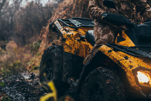 Tough terrain for a tough man Close up of man driving fix quad on a muddy path off road vehicle stock pictures, royalty-free photos & images