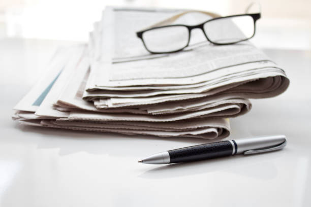 istock A stack of newspapers with glasses and pencil. 1074629420