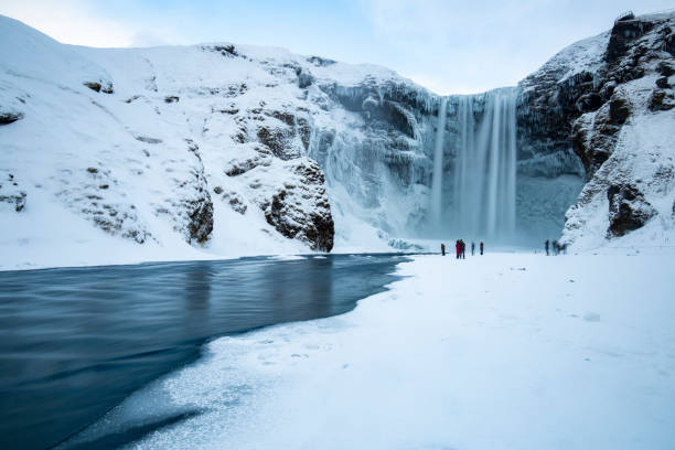 Skogafoss Panorama in Winter Famous skogafoss Waterfall in iceland on a winter day with some tourists arround.Famous skogafoss Waterfall in iceland on a winter day with some tourists arround. skogafoss stock pictures, royalty-free photos & images