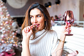 Beautiful woman eating cake-pop and holding a wine glass