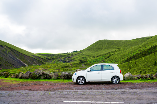 Lisbon, Portugal - November 10, 2017: Small white car standing by the road side on the Sao Miguel island, Azores.