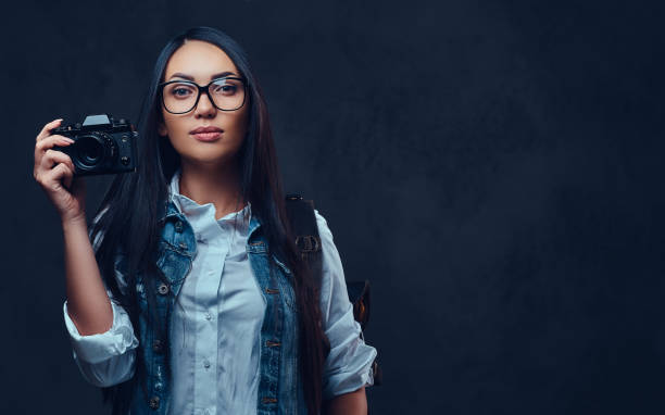 istock A woman with backpack holds compact photo camera. 1074647160