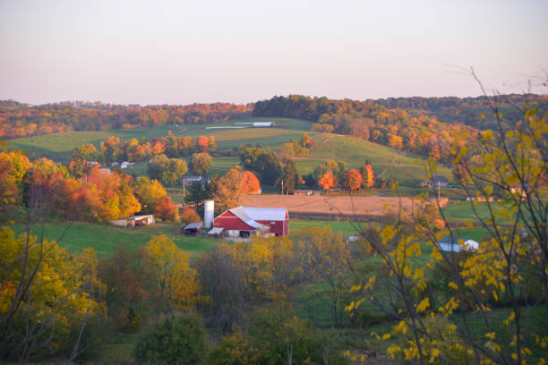 Red Barn Surrounded by Colorful Autumn Trees Red Barn in a valley, surrounded by hills covered with color autumn trees - Amish Country in Walnut Creek, Ohio. Amish stock pictures, royalty-free photos & images