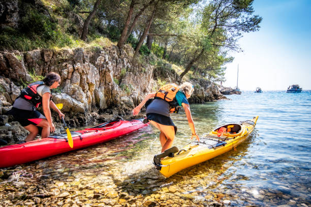 istock Two women boarding their kayaks on a Mediterranean beach 1074651402