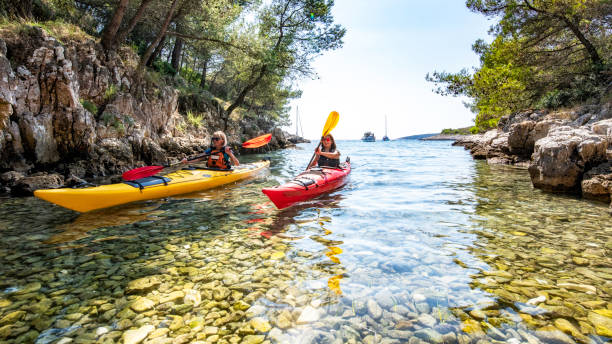 istock Two women kayaking into a small bay in the Mediterranean 1074651436