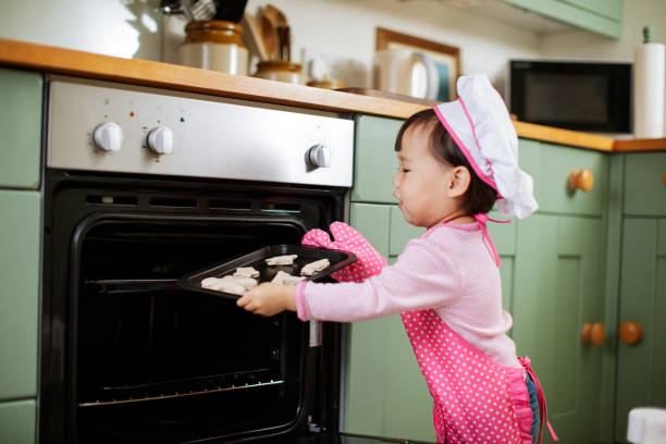 istock baby girl pretend baking at home 1074653532
