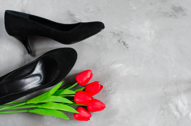 istock Classic black women's black shoes and red tulips. 1074653832
