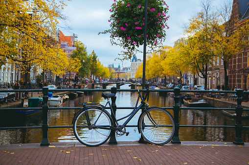 Canal in the center of the city at sunset. Bicycles standing on the bridge with an amazing Amsterdam view.