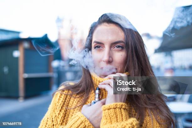 Woman Vaping An Electronic Cigarette Stock Photo - Download Image Now - Electronic Cigarette, Cigarette, Electronics Industry